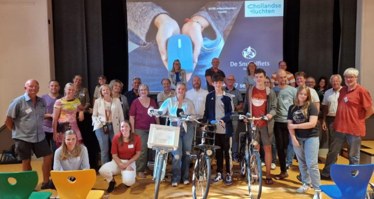 Een groep mensen poseert voor een scherm met SODAQ Air en drie 'snuffelfietsen'