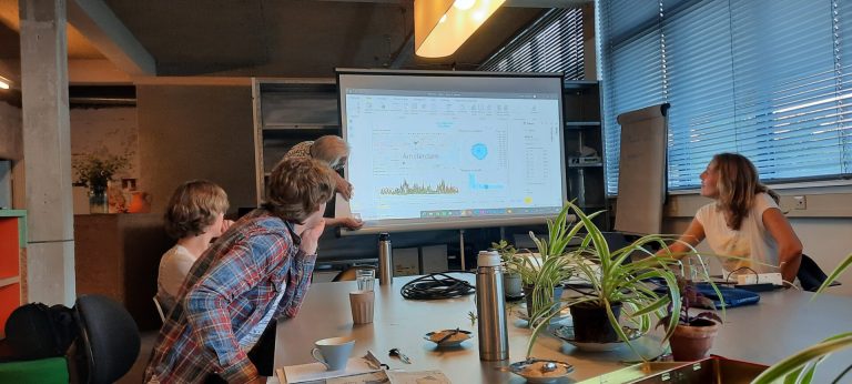 Mensen kijken naar een geprojecteerde presentatieslide met grafieken